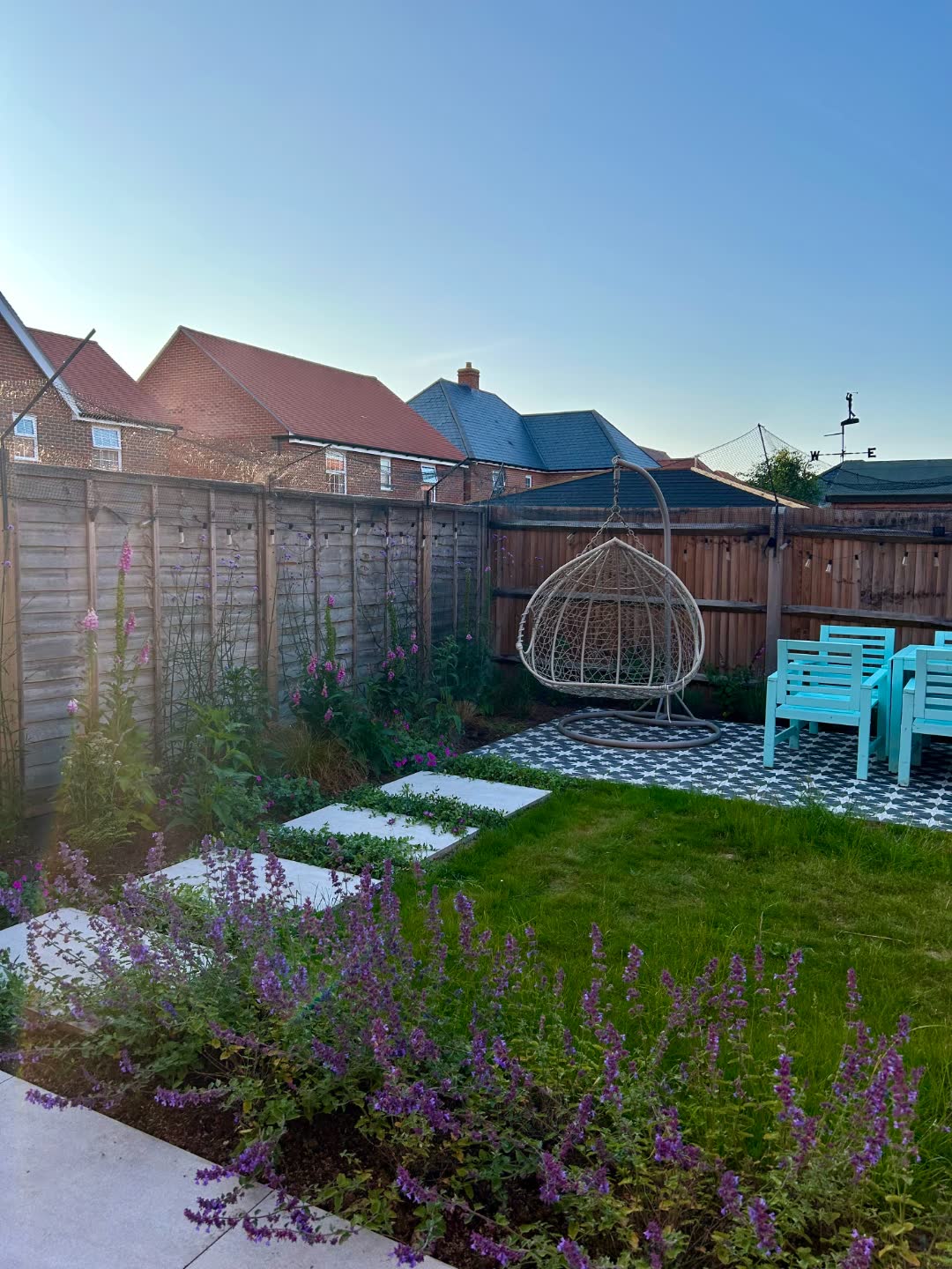 A completed private garden with porcelain stepping stones, hanging chair and patterned tiles